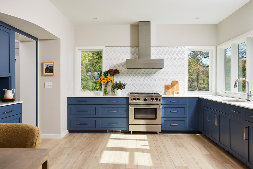 Mid-sized scandinavian kitchen in Minneapolis with blue cabinets and white benchtop.