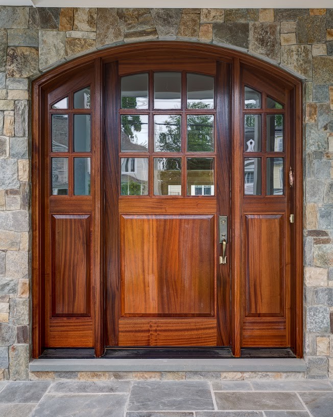 This is an example of a small traditional front door in DC Metro with limestone floors, a single front door and a dark wood front door.