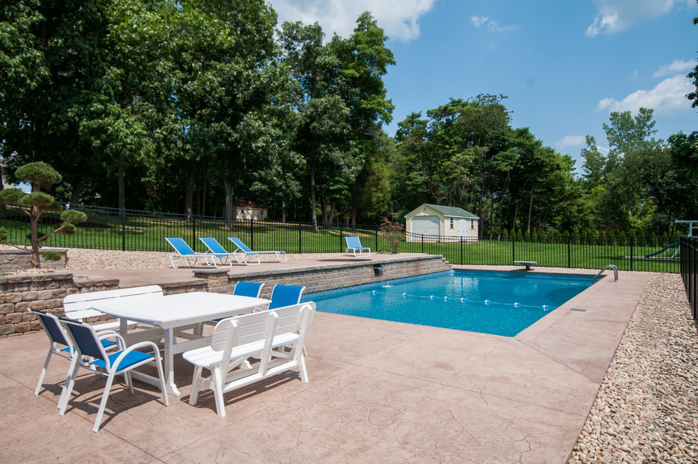 Pool fountain - backyard stamped concrete and rectangular pool fountain idea in Boston