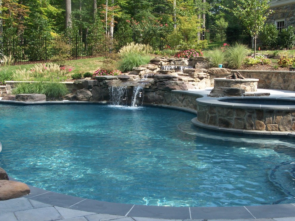 Inspiration for a mid-sized eclectic backyard custom-shaped natural pool in DC Metro with a water feature and concrete pavers.