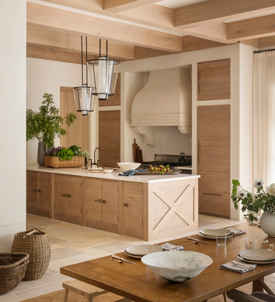 Foto på ett kök och matrum, med bänkskiva i kalksten, stänkskydd i kalk, rostfria vitvaror, kalkstensgolv och en köksö