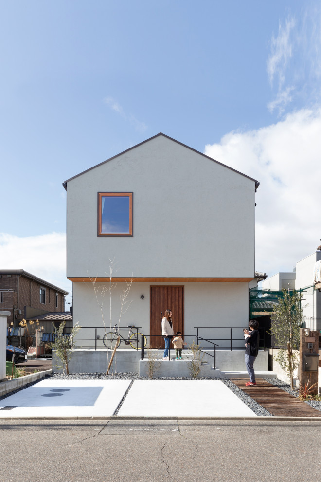 Cette photo montre une façade de maison blanche tendance à un étage avec un toit à deux pans.