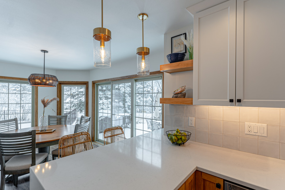 Bild på ett mellanstort maritimt vit vitt kök, med en undermonterad diskho, skåp i shakerstil, vita skåp, bänkskiva i kvarts, beige stänkskydd, stänkskydd i keramik, rostfria vitvaror, mellanmörkt trägolv, en halv köksö och brunt golv