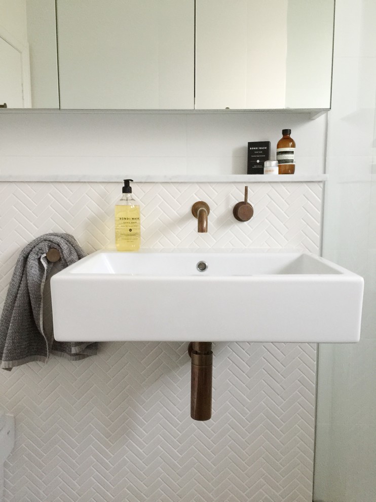 Photo of a large modern bathroom in Sydney with a wall-mount sink, marble benchtops, an open shower, a wall-mount toilet, white tile, mosaic tile, white walls and concrete floors.