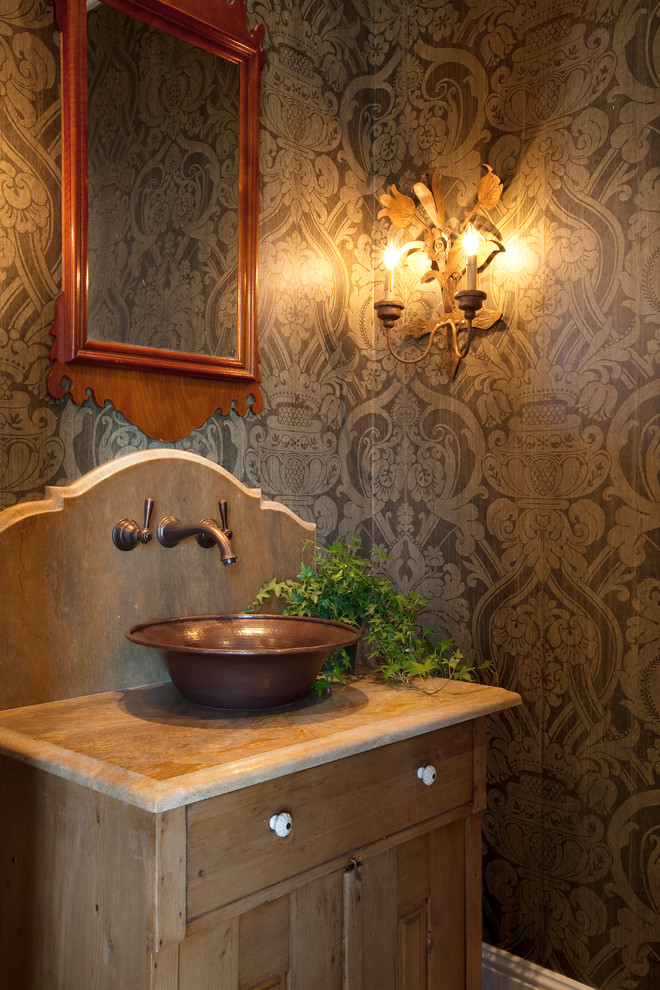 Photo of a country powder room in Nashville with a vessel sink, medium wood cabinets and brown benchtops.
