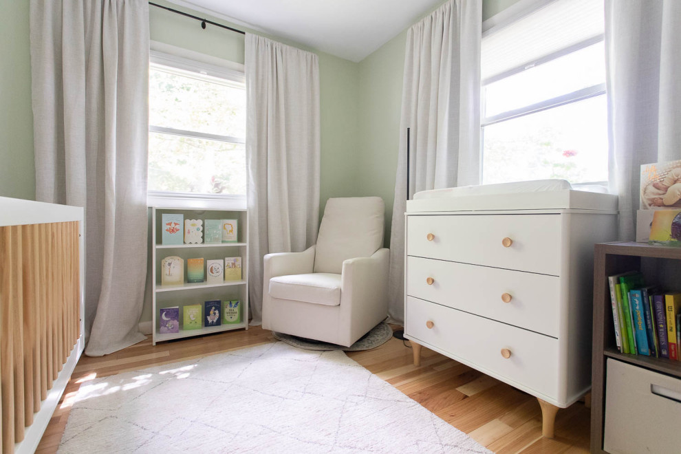 Aménagement d'une petite chambre de bébé neutre contemporaine avec un mur vert et parquet clair.
