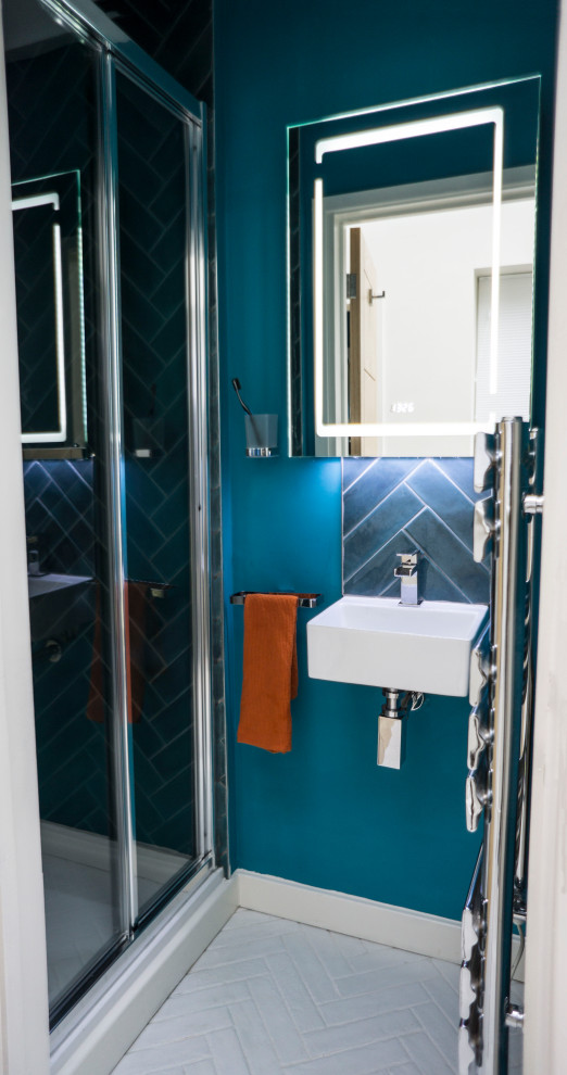 Photo of a small scandinavian 3/4 bathroom in Kent with a curbless shower, blue tile, porcelain tile, blue walls, porcelain floors, a wall-mount sink, white floor and a sliding shower screen.