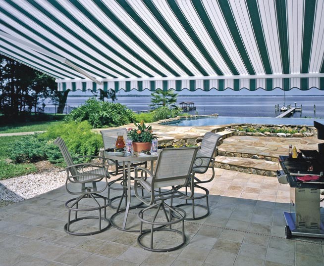 Example of a large classic backyard tile patio design in Orange County with an awning
