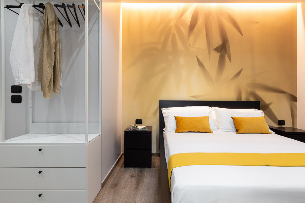 Diseño de dormitorio principal actual grande con paredes amarillas, suelo de baldosas de porcelana, suelo beige y papel pintado