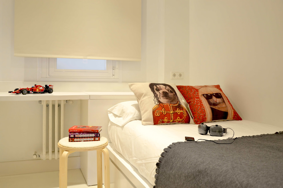 Photo of a mid-sized scandinavian gender-neutral kids' room in Madrid with white walls.