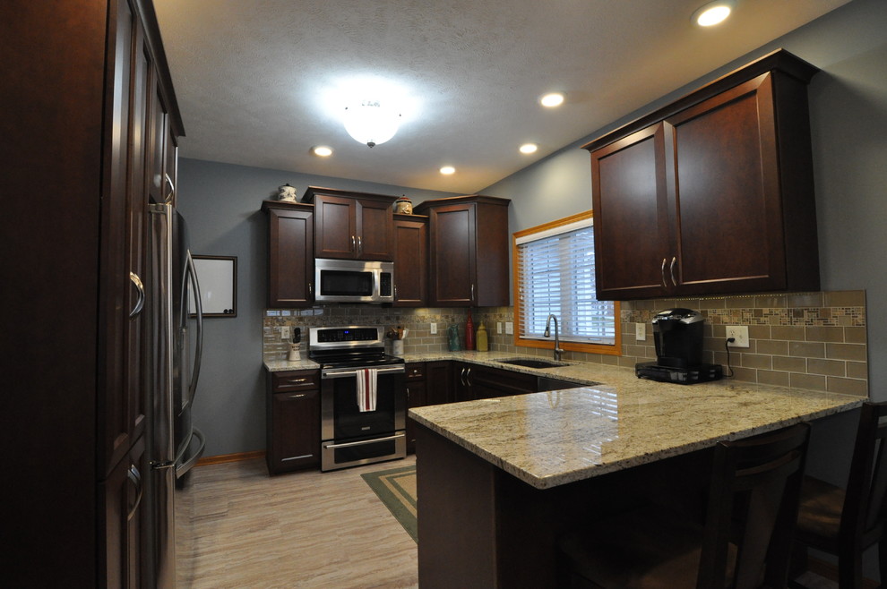 Eat-in kitchen - mid-sized transitional u-shaped porcelain tile eat-in kitchen idea with an undermount sink, recessed-panel cabinets, dark wood cabinets, granite countertops, beige backsplash and stainless steel appliances
