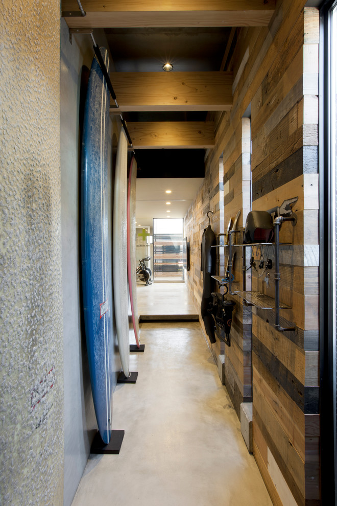 Design ideas for a mid-sized industrial entry hall in Yokohama with brown walls and concrete floors.