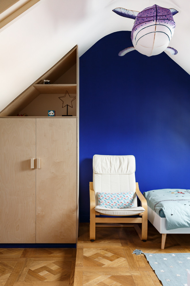 Idée de décoration pour une chambre d'enfant de 4 à 10 ans nordique de taille moyenne avec un mur bleu, parquet clair et un sol beige.