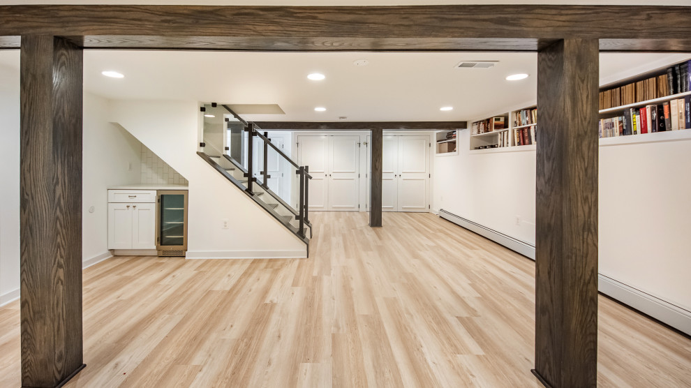 Small transitional walk-out vinyl floor and brown floor basement photo in DC Metro with white walls and a standard fireplace