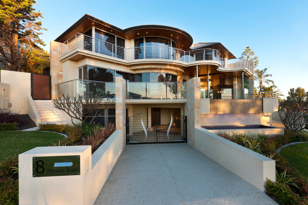 Photo of a contemporary three-storey stucco beige house exterior in Perth.