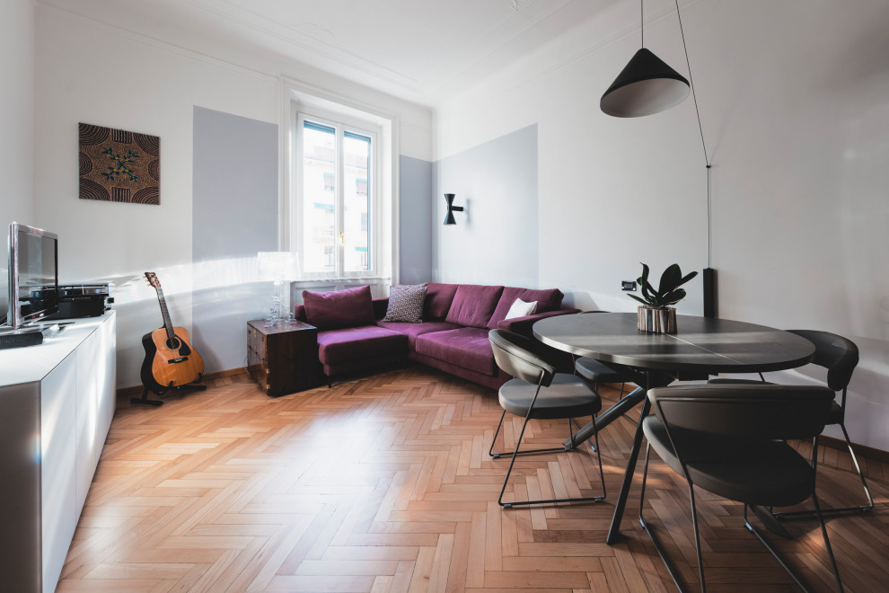 Inspiration for a medium sized eclectic enclosed games room in Milan with a reading nook, grey walls, light hardwood flooring, a freestanding tv and beige floors.