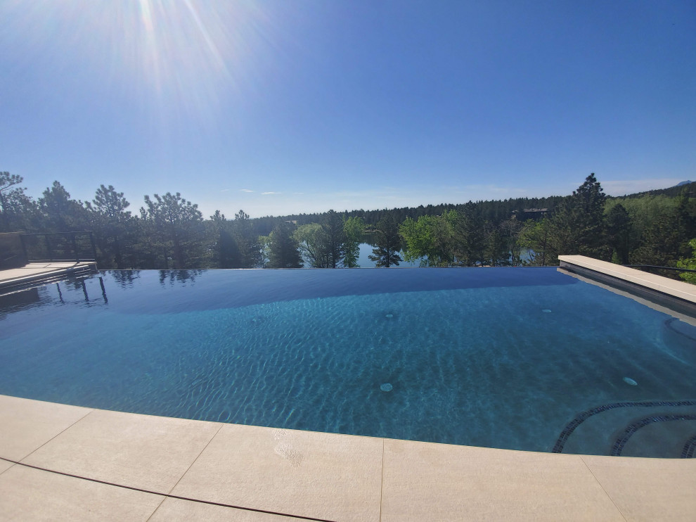 Mid-sized backyard rectangular infinity hot tub photo in Denver