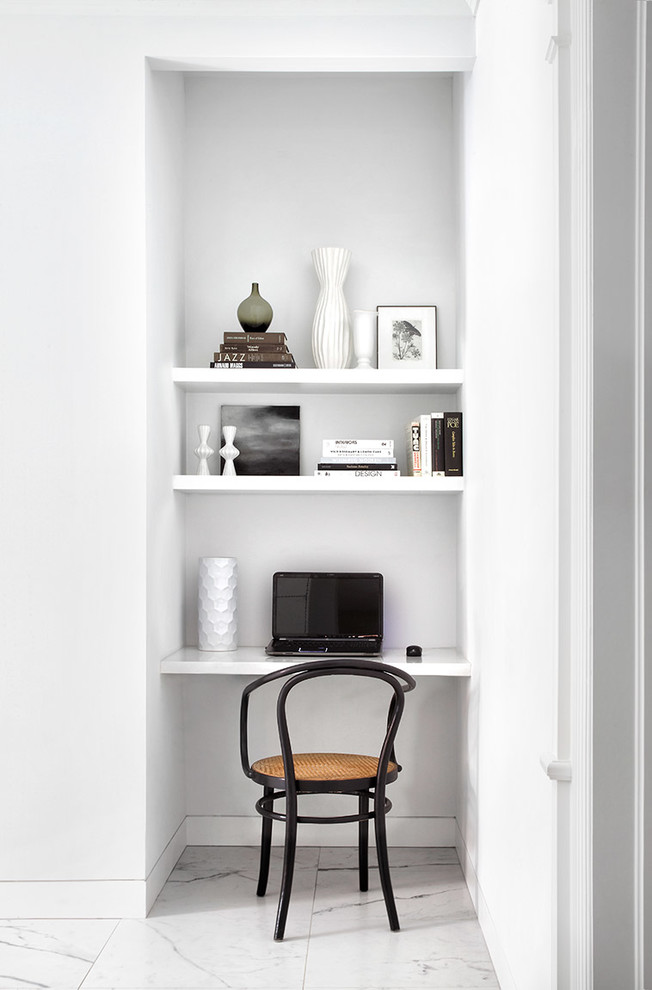 Scandinavian home office in Toronto with white walls, a built-in desk and white floor.