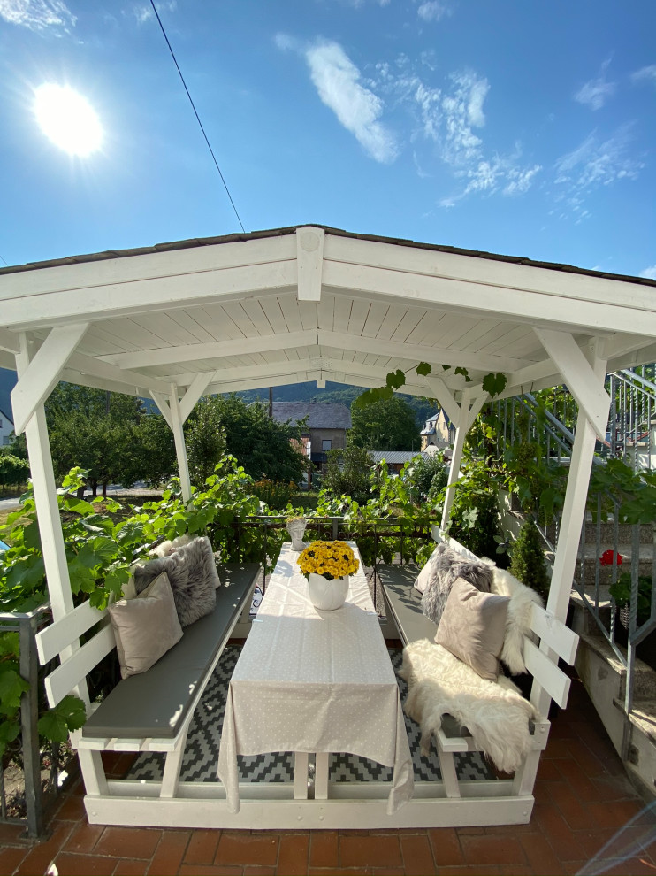 Kleine, Überdachte Landhausstil Terrasse neben dem Haus mit Sichtschutz in Köln