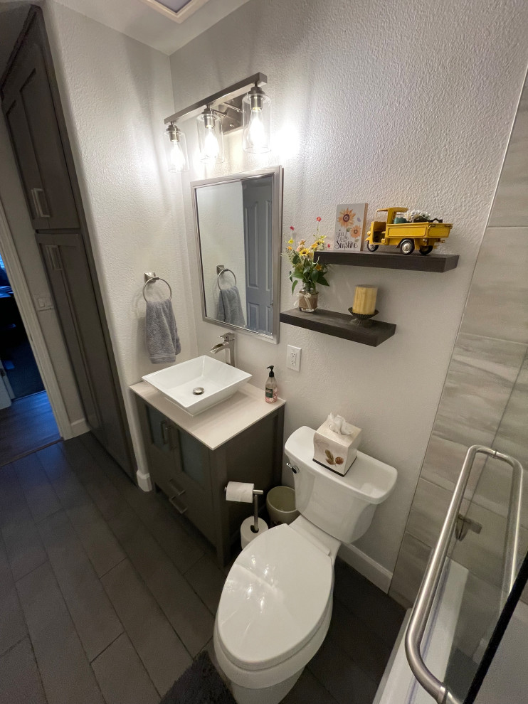 Cette photo montre une douche en alcôve chic de taille moyenne avec un placard en trompe-l'oeil, des portes de placard grises, une baignoire posée, WC séparés, un carrelage multicolore, des carreaux de porcelaine, un mur beige, un sol en carrelage de porcelaine, un lavabo encastré, un plan de toilette en quartz modifié, un sol gris, une cabine de douche à porte battante, un plan de toilette multicolore, une niche, meuble double vasque et meuble-lavabo sur pied.
