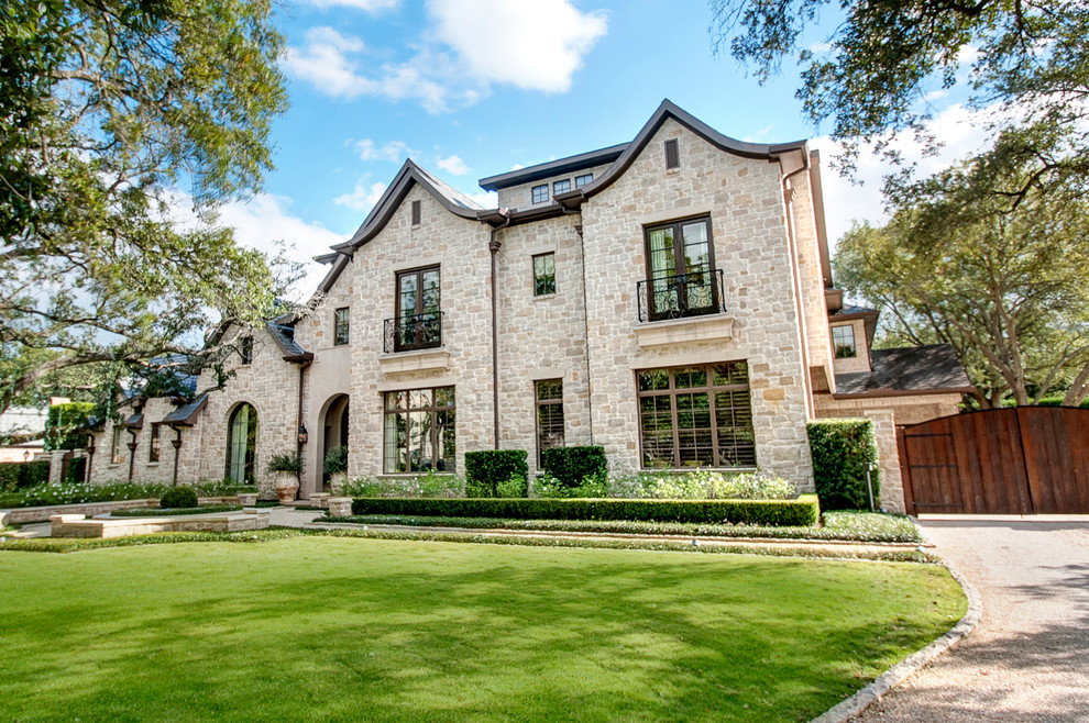 Inspiration for an expansive mediterranean three-storey beige exterior in Houston with stone veneer and a gable roof.