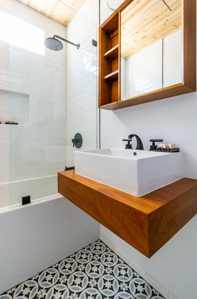 This is an example of a medium sized modern shower room bathroom in Los Angeles with all styles of cabinet, dark wood cabinets, a built-in bath, a shower/bath combination, a bidet, white tiles, metro tiles, white walls, mosaic tile flooring, a built-in sink, wooden worktops, black floors, an open shower, brown worktops, a single sink, a floating vanity unit and a wood ceiling.