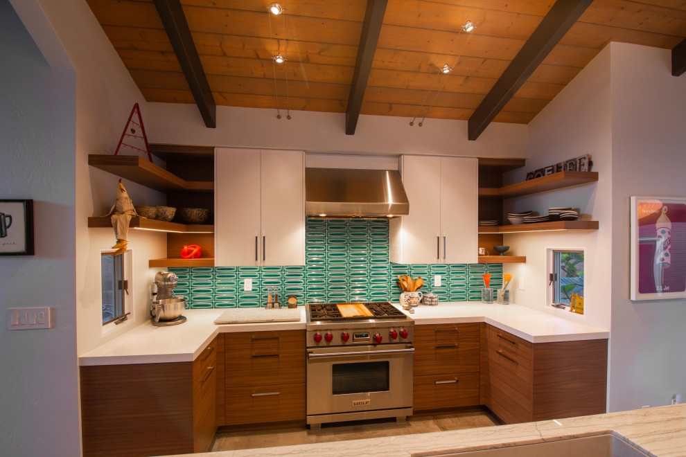 サンディエゴにある広いミッドセンチュリースタイルのおしゃれなキッチン (アンダーカウンターシンク、フラットパネル扉のキャビネット、緑のキッチンパネル、シルバーの調理設備、ベージュのキッチンカウンター、塗装板張りの天井) の写真