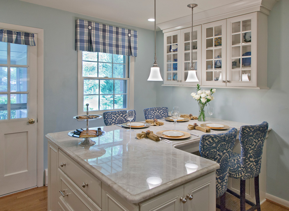 Mid-sized transitional l-shaped light wood floor and brown floor eat-in kitchen photo in Baltimore with recessed-panel cabinets, white cabinets, marble countertops, a peninsula, an undermount sink, white backsplash, mosaic tile backsplash and stainless steel appliances