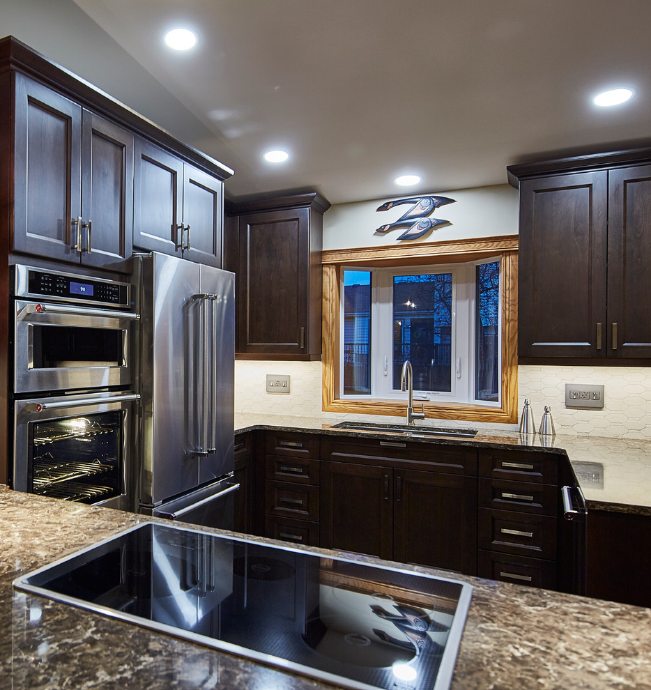 Mid-sized transitional u-shaped porcelain tile eat-in kitchen photo with an undermount sink, shaker cabinets, dark wood cabinets, quartz countertops, beige backsplash, stone tile backsplash, stainless steel appliances and a peninsula
