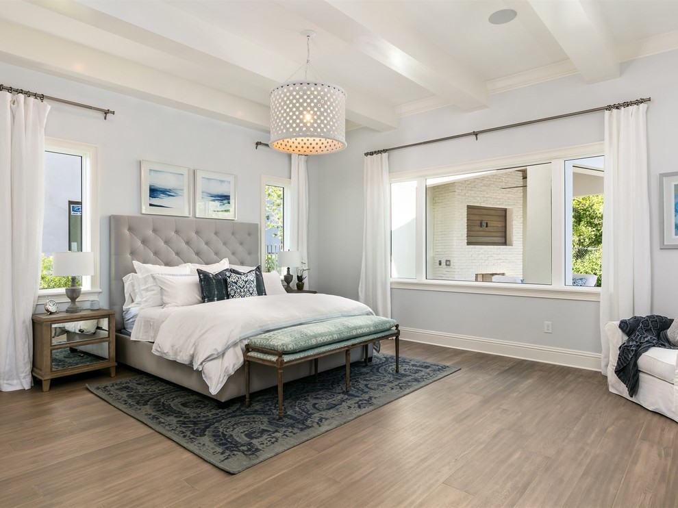 Design ideas for a large beach style master bedroom in Orlando with blue walls, no fireplace, dark hardwood floors and brown floor.