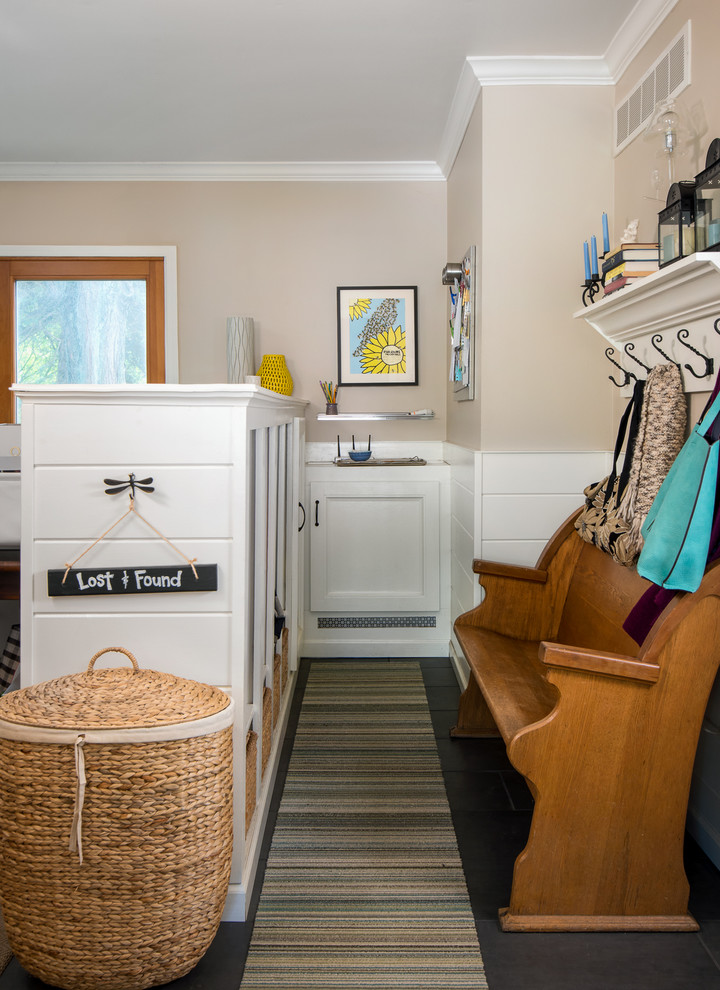 This is an example of a small eclectic mudroom in Detroit with beige walls, porcelain floors and a white front door.