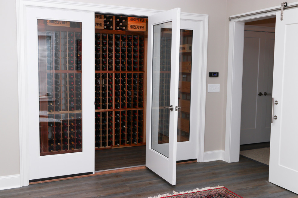 This is an example of a mid-sized traditional wine cellar in Atlanta with dark hardwood floors, storage racks and brown floor.