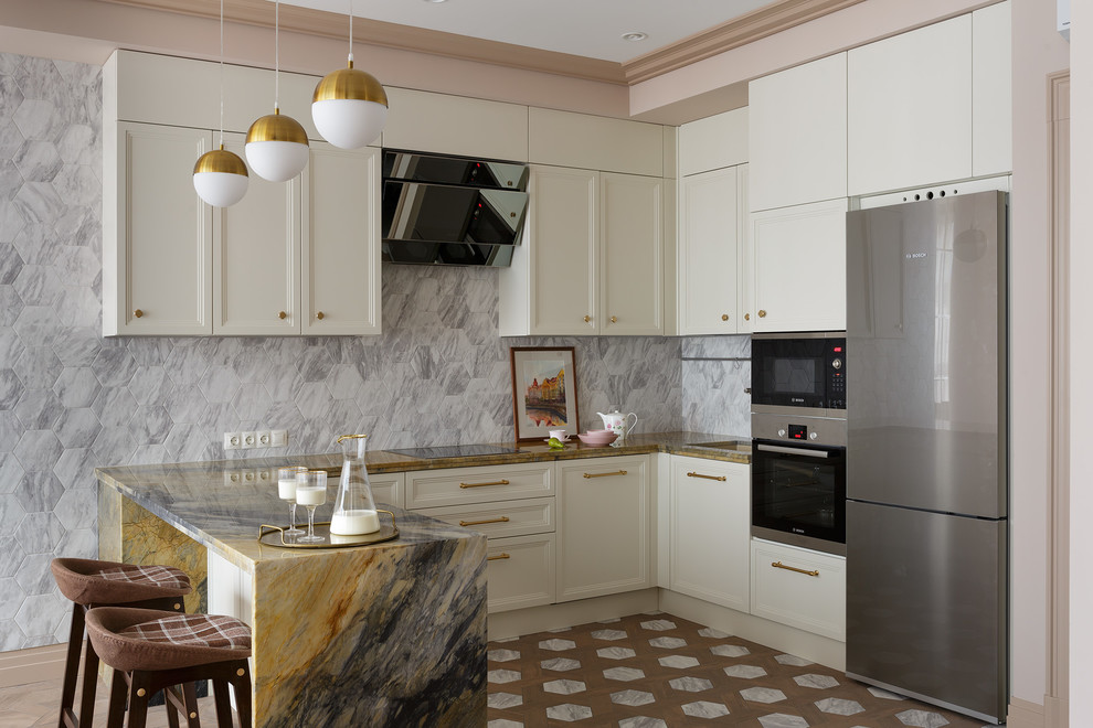Inspiration for a mid-sized traditional u-shaped eat-in kitchen in Saint Petersburg with an undermount sink, recessed-panel cabinets, quartzite benchtops, grey splashback, porcelain splashback, stainless steel appliances, porcelain floors, a peninsula, brown floor, brown benchtop and white cabinets.