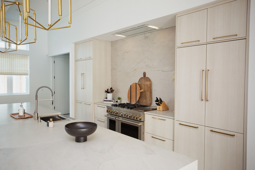 Photo of a large contemporary single-wall eat-in kitchen in Miami with a drop-in sink, flat-panel cabinets, beige cabinets, quartzite benchtops, beige splashback, marble splashback, panelled appliances, light hardwood floors, with island, beige floor and beige benchtop.