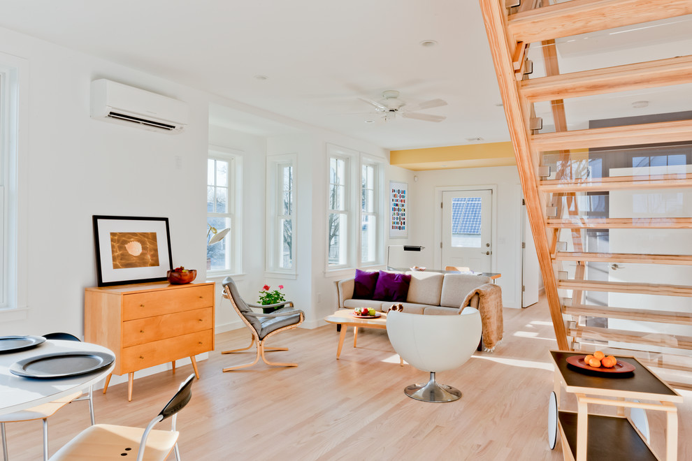 This is an example of a mid-sized contemporary open concept living room in Boston with white walls and light hardwood floors.