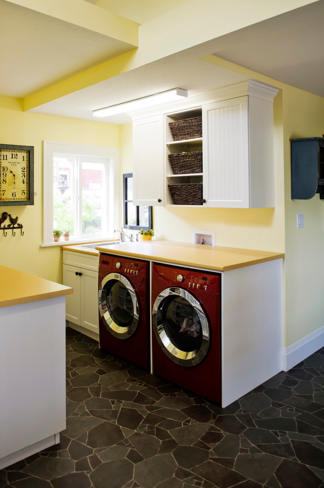 Photo of a small eclectic galley utility room in Vancouver with a drop-in sink, shaker cabinets, white cabinets, laminate benchtops, yellow walls, vinyl floors, a side-by-side washer and dryer and yellow benchtop.