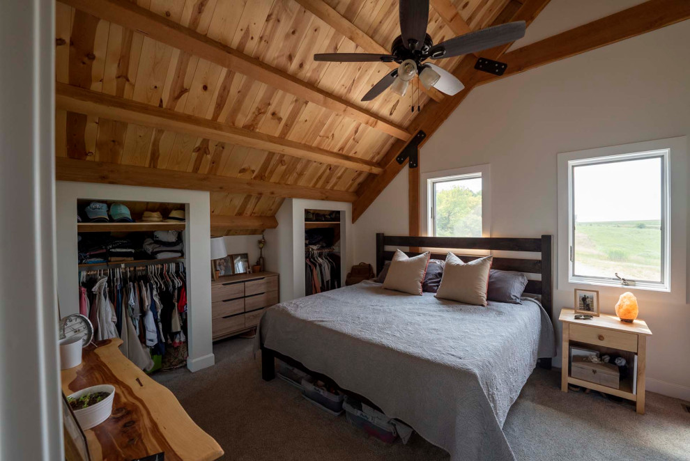 Foto di una camera matrimoniale stile rurale di medie dimensioni con pareti beige, moquette, pavimento beige, soffitto a volta e pareti in legno