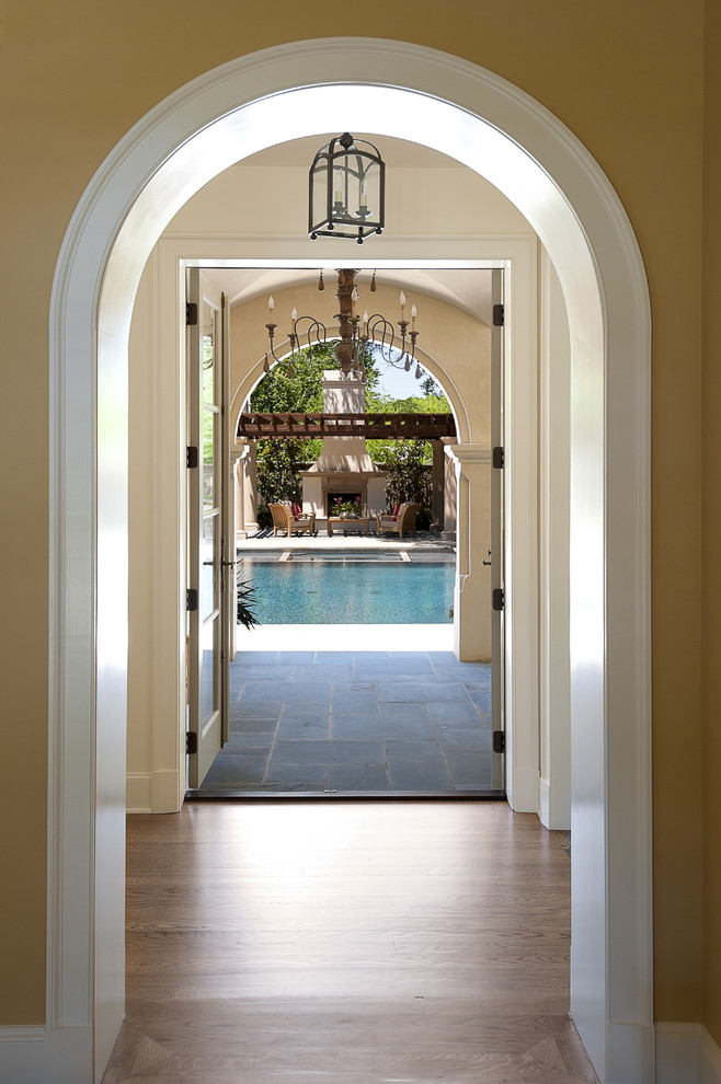 Inspiration for a mid-sized mediterranean hallway in Dallas with yellow walls and medium hardwood floors.