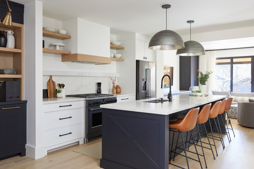 Inspiration for a small transitional galley open plan kitchen in Toronto with an undermount sink, recessed-panel cabinets, white cabinets, quartz benchtops, white splashback, stone slab splashback, coloured appliances, light hardwood floors, with island, beige floor and white benchtop.