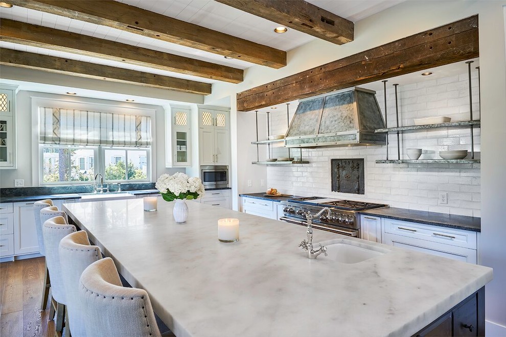 Example of a cottage eat-in kitchen design in Charleston with an undermount sink, white cabinets, marble countertops, white backsplash, stainless steel appliances, an island and beaded inset cabinets