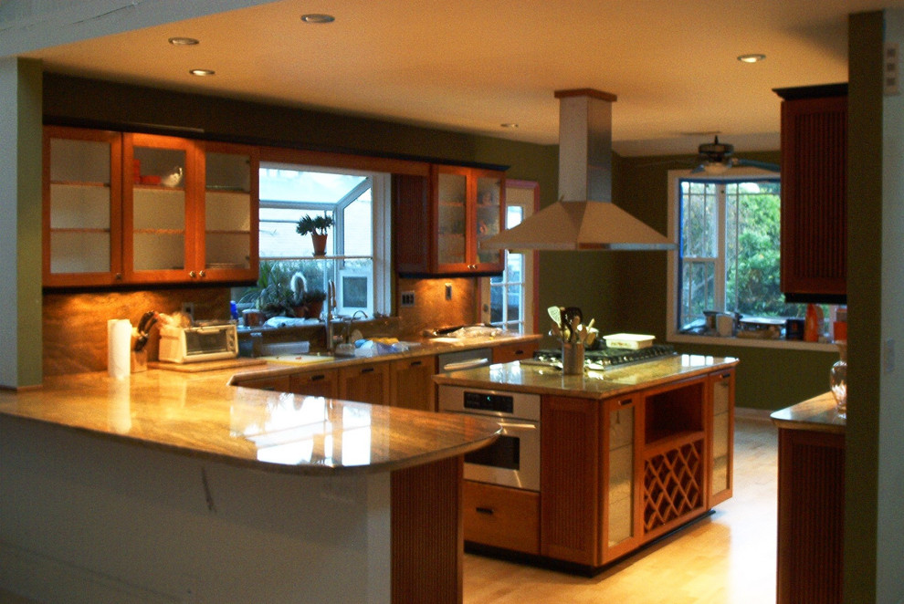 Photo of a small eclectic galley eat-in kitchen in Orange County with a drop-in sink, glass-front cabinets, brown cabinets, granite benchtops, multi-coloured splashback, granite splashback, stainless steel appliances, light hardwood floors, with island, yellow floor, multi-coloured benchtop and coffered.
