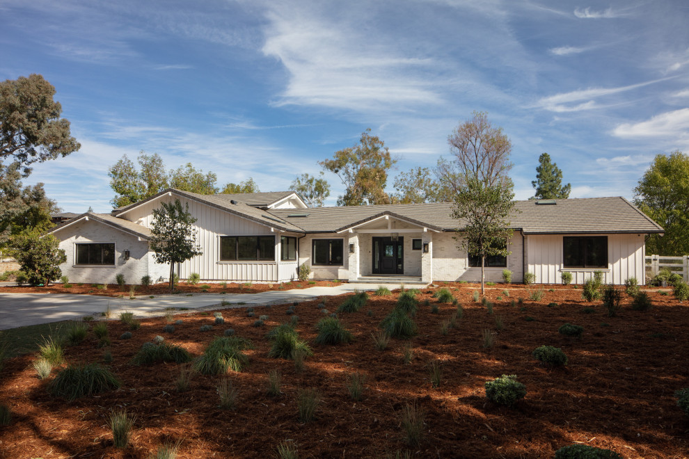 Photo of a medium sized and white country split-level detached house in Santa Barbara with mixed cladding, a pitched roof, a shingle roof, a grey roof and board and batten cladding.