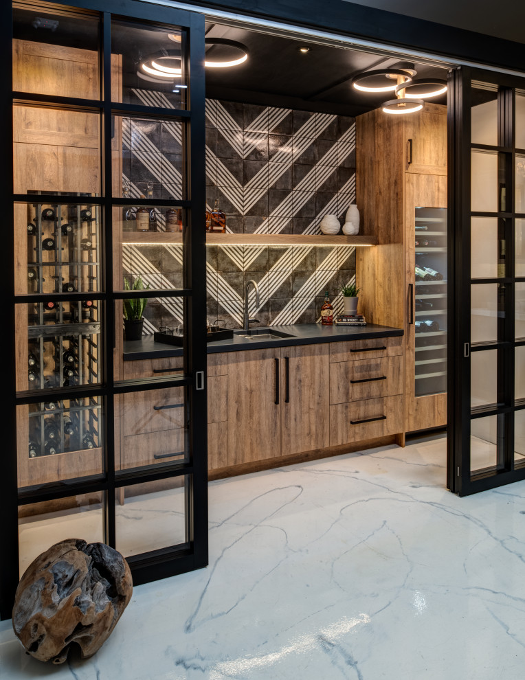 Mid-sized transitional single-wall wet bar in Other with an undermount sink, flat-panel cabinets, light wood cabinets, concrete benchtops, black splashback, porcelain splashback, concrete floors, white floor and black benchtop.