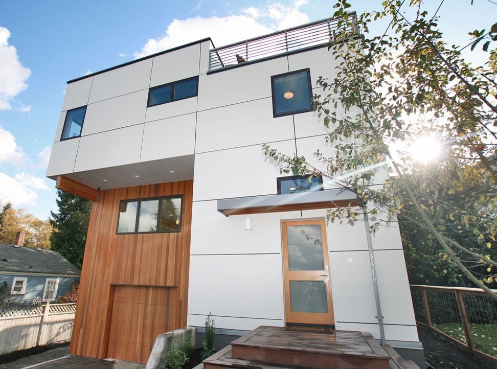 Photo of a mid-sized contemporary grey exterior in Seattle with mixed siding and a flat roof.