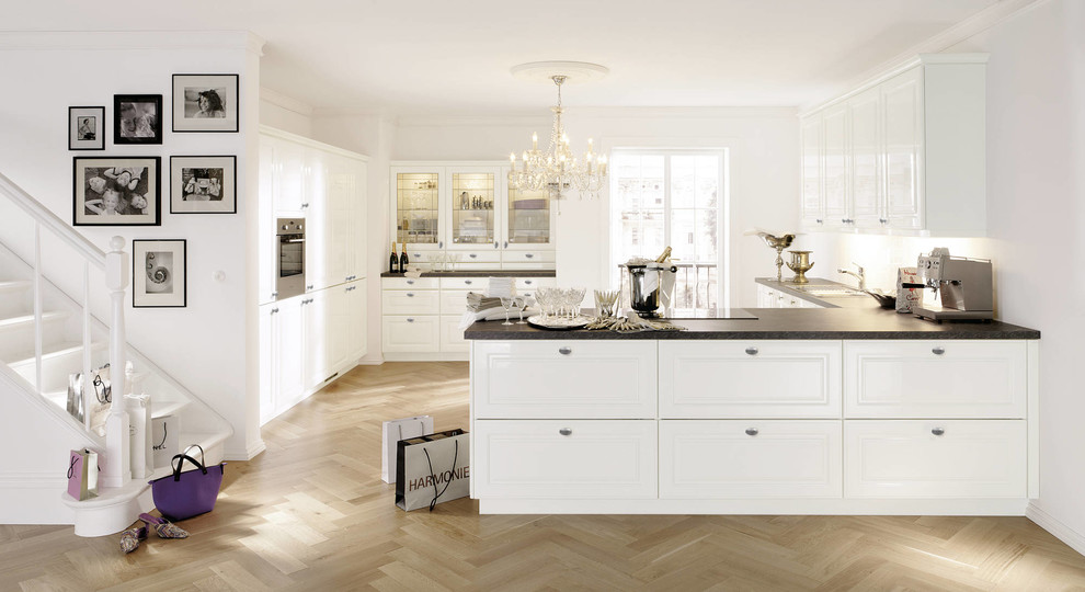 Design ideas for a mid-sized transitional l-shaped eat-in kitchen in New York with a drop-in sink, beaded inset cabinets, white cabinets, soapstone benchtops, stainless steel appliances, light hardwood floors and a peninsula.