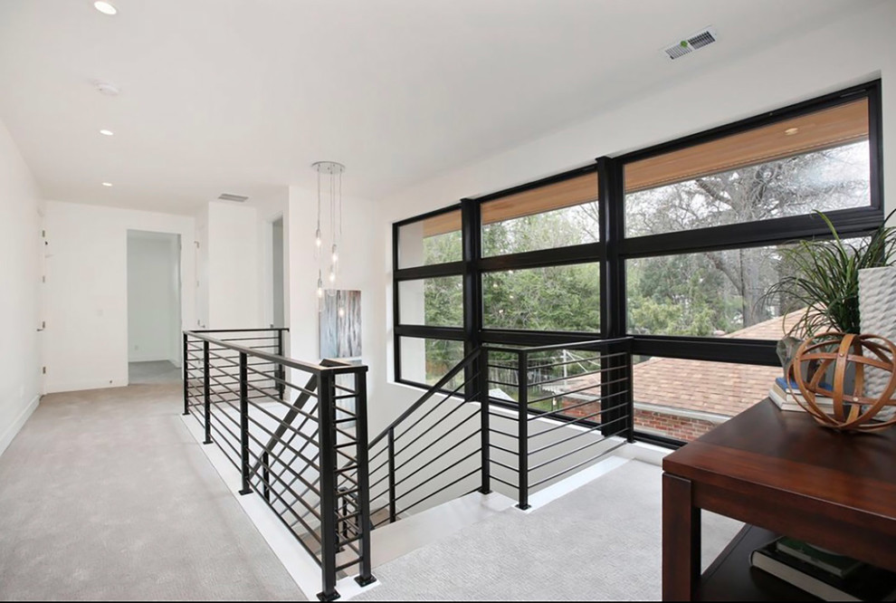 Photo of a mid-sized contemporary wood u-shaped staircase in Denver with metal risers and metal railing.
