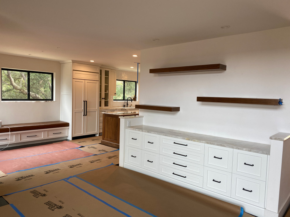 На фото: изолированная, серо-белая гостиная комната среднего размера в стиле неоклассика (современная классика) с белыми стенами, темным паркетным полом, печью-буржуйкой и черным полом
