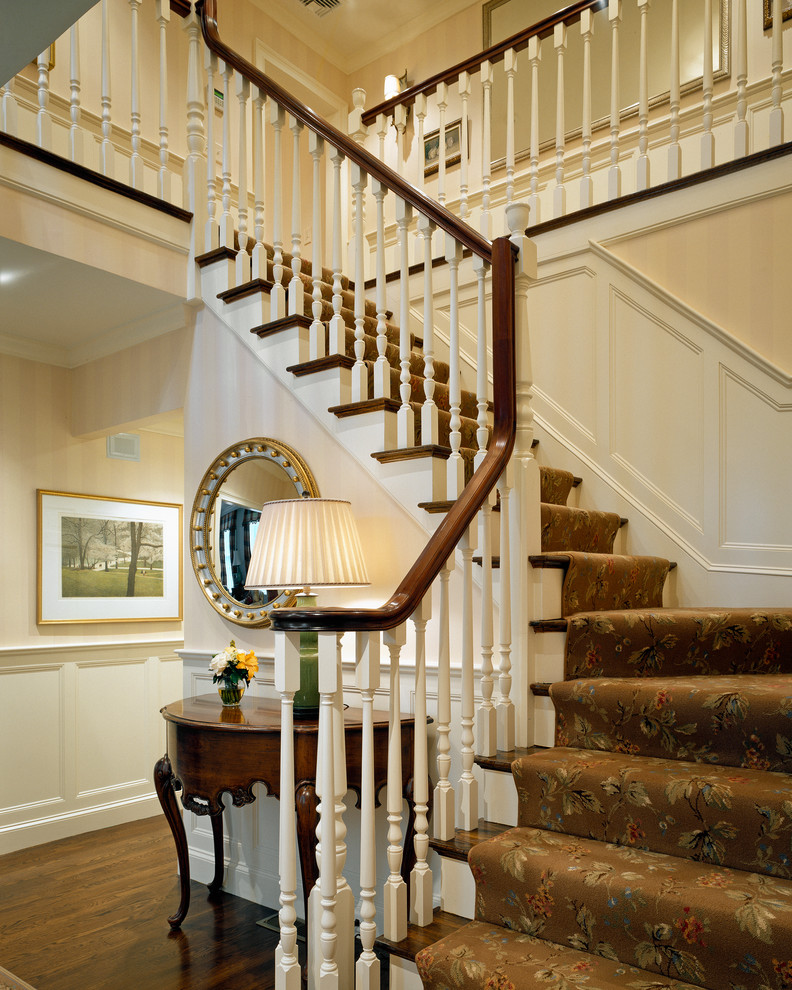 Photo of a large traditional wood l-shaped staircase in Boston with wood risers and wood railing.
