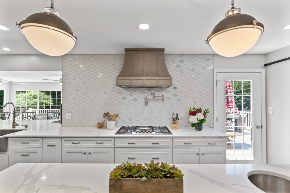 Inspiration for a mid-sized transitional single-wall dark wood floor and brown floor eat-in kitchen remodel in DC Metro with a farmhouse sink, recessed-panel cabinets, white cabinets, quartzite countertops, white backsplash, glass tile backsplash, stainless steel appliances, two islands and white countertops
