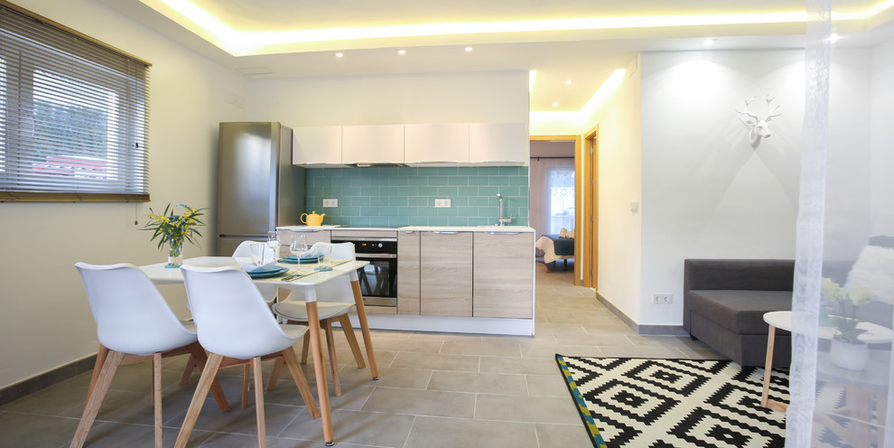 This is an example of a small mediterranean single-wall eat-in kitchen in Malaga with flat-panel cabinets, light wood cabinets, blue splashback, cement tile splashback, ceramic floors and no island.